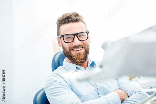 Fototapeta Naklejka Na Ścianę i Meble -  Handsome businessman with great smile sitting on the dental chair