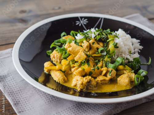 Delicious turkey mango curry with rice on a black plate