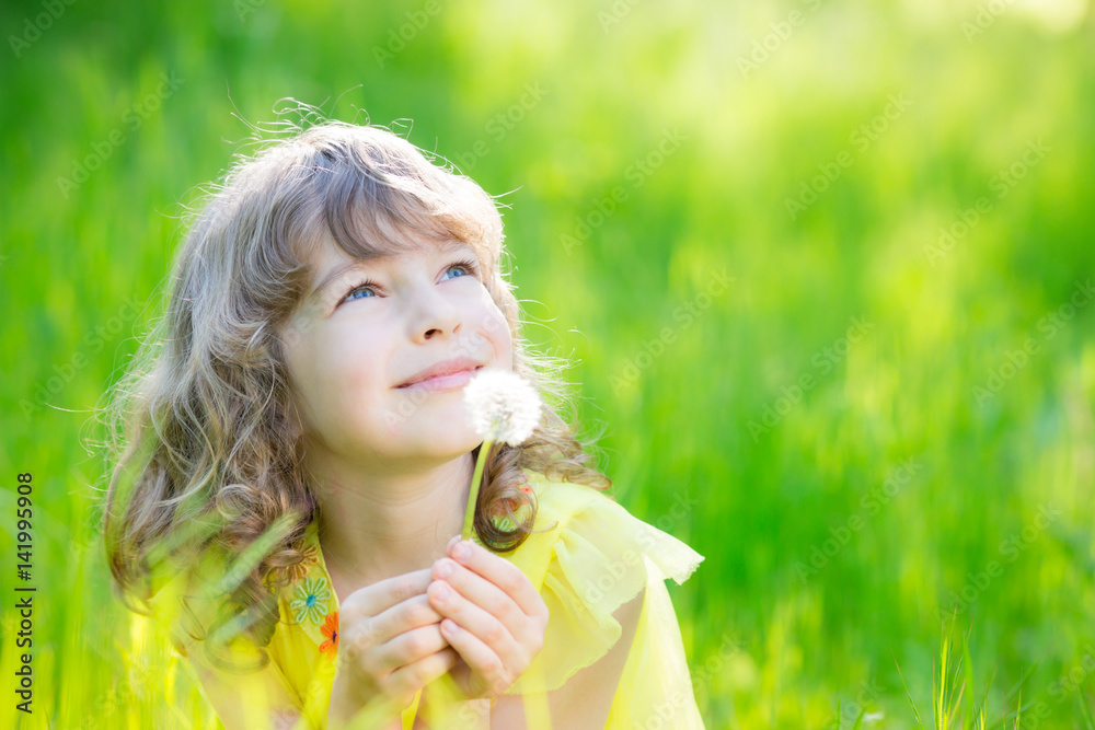 Happy child blowing dandelion flower outdoors Happy child blowing dandelion flower outdoors