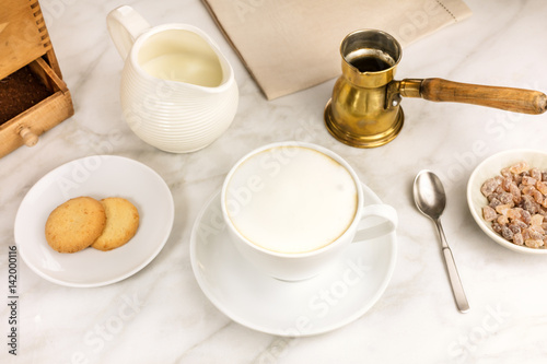 Cup of cappuccino, butter cookie and milk jar