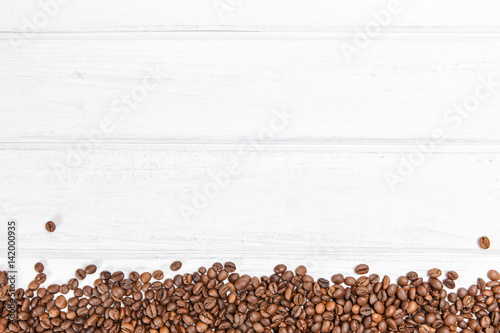   offee beans stripe on white wood background.  Copyspace for text.