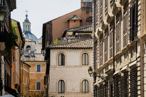 View over old facades and roofs of Italian houses and a cathedral in the historical center of Rome