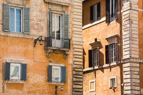 Old yellow facades of Italian houses with open wooden windows in the historical center of Rome © Anastasiia