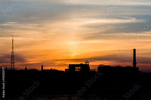 Dramatic sunset over the city silhouette near water