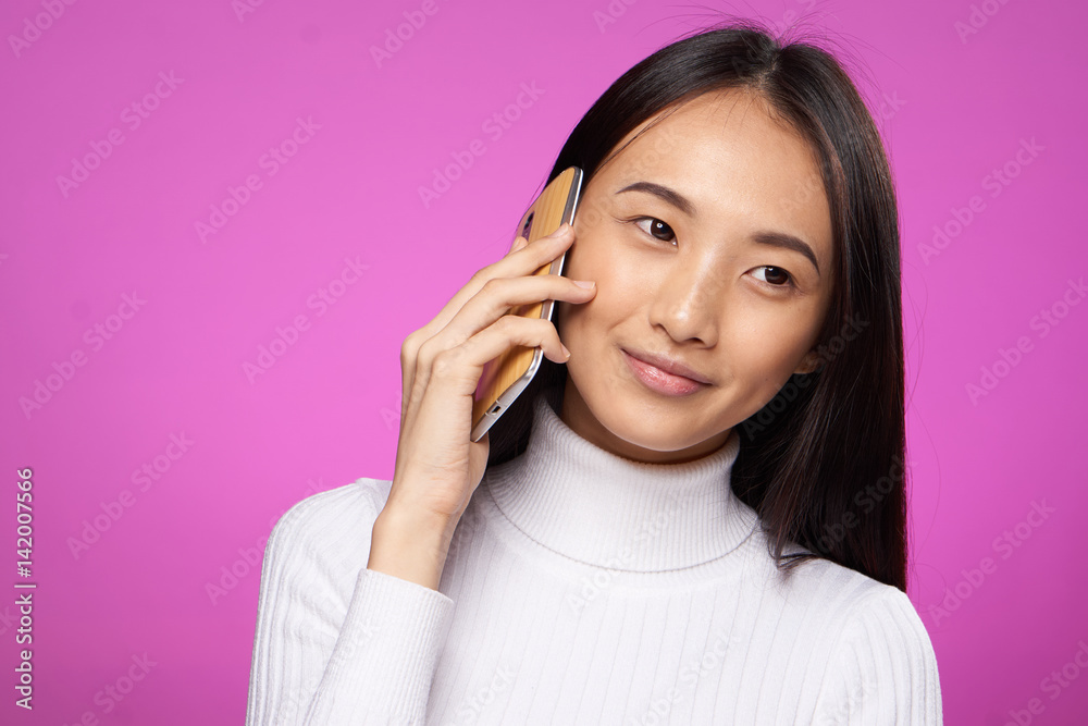 beautiful brunette on a pink background talking on the phone beautiful brunette on a pink background talking on the phone