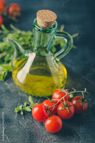 Fototapeta Naklejka Na Ścianę i Meble -  Bottle with vegetable oil and cherry tomatoes