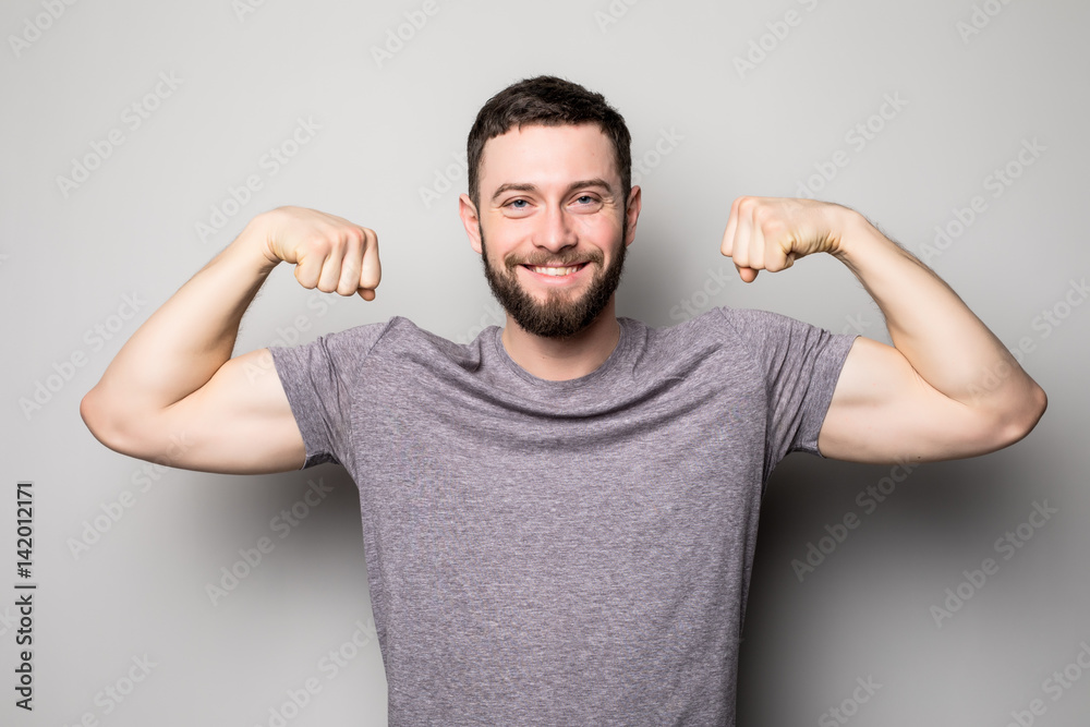 young man with relief muscles in jeans in shirt on a gray background young man with relief muscles in jeans in shirt on a gray background