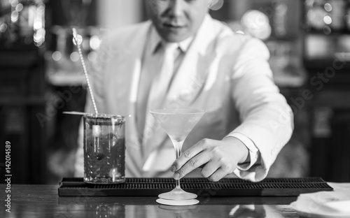 Chinese Barman is making cocktail at night club.