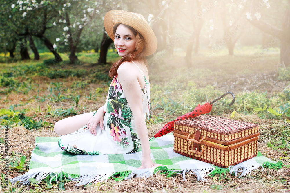 Obraz premium girl on a picnic in the apple orchard with basket of products