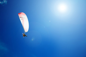 Fotobehang Luchtsport Paraglider drijft in heldere blauwe hemel  © Kiryl Lis