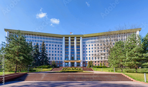 Parliament of the republic of moldova in chisinau, national flag, stefan cel mare street, spring time with blue sky photo