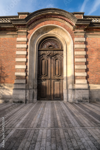Fantasy wooden door in brick arc Epernay, Avenue de Champagne, France