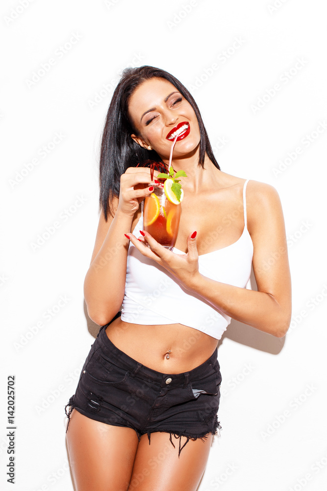 Happy woman laughing with cocktail at wall Happy woman laughing with cocktail at wall