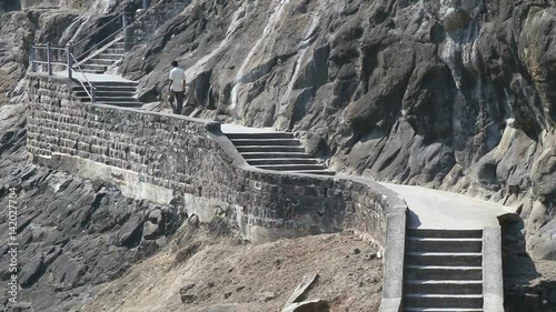 Man walking up the stairs outside of Aurangabad caves.