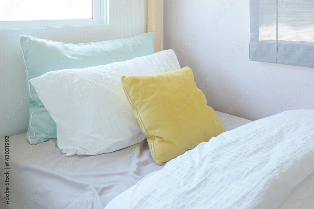 Yellow and green pillow on tiny bed in kid bedroom interior