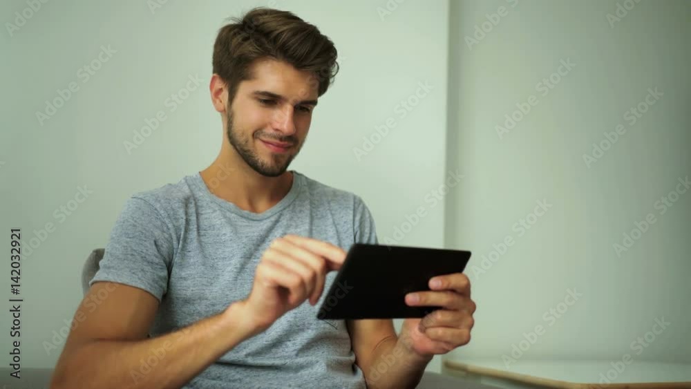 Handsome man using tablet pc at home Handsome man using tablet pc at home
