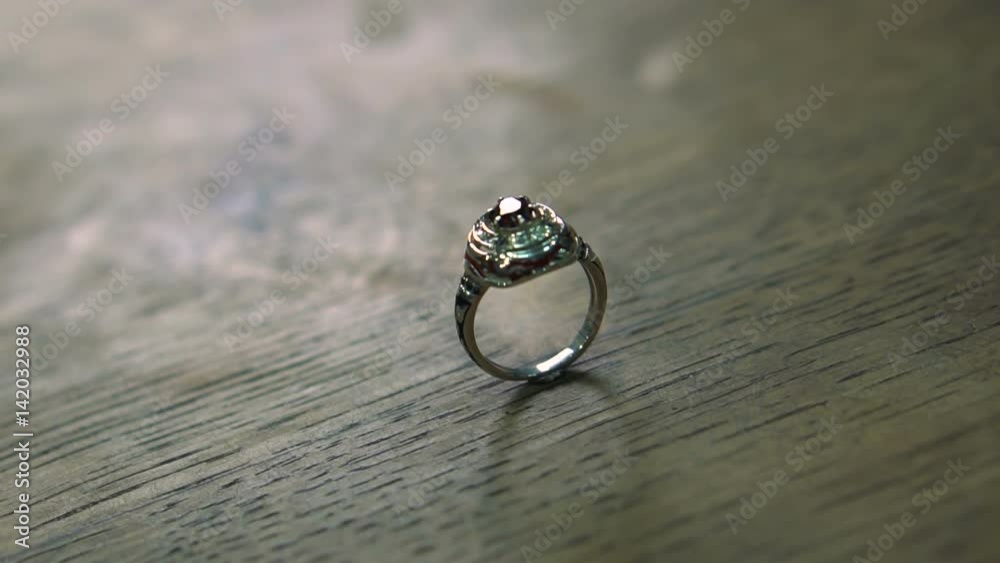 Ring made by the goldsmith on the customer's request is ready and is on a wooden table Ring made by the goldsmith on the customer's request is ready and is on a wooden table