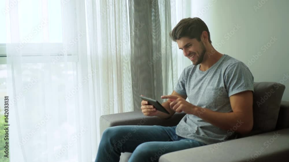 Handsome man using tablet pc at home Handsome man using tablet pc at home