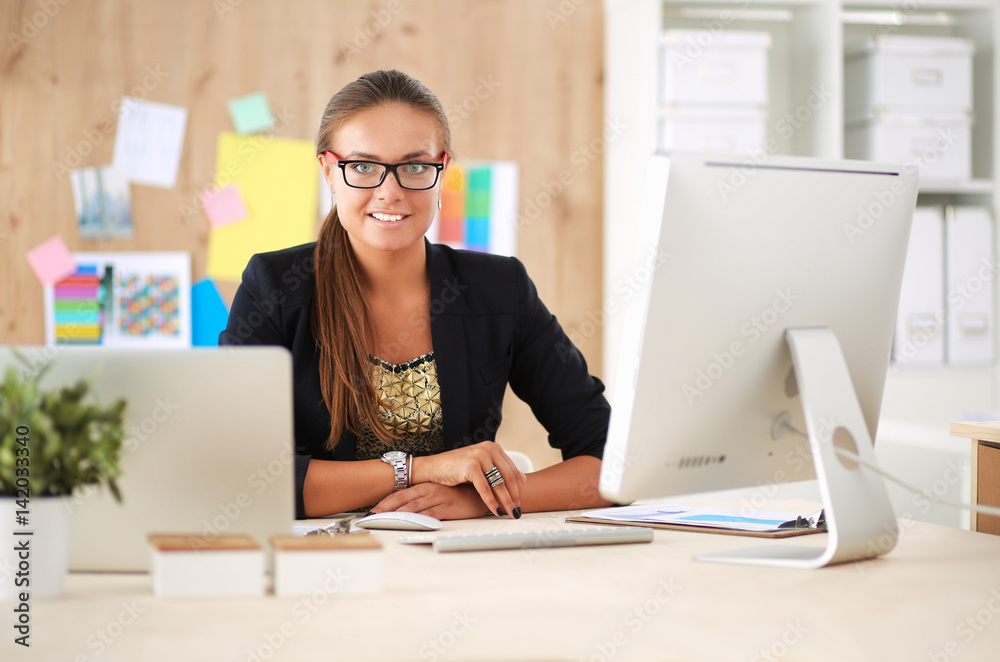 Fashion designers working in studio sitting on the desk