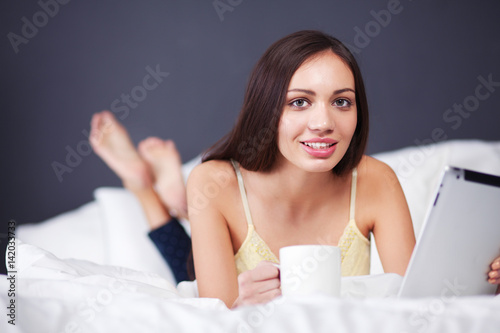 Women use a tablet pc on the bed