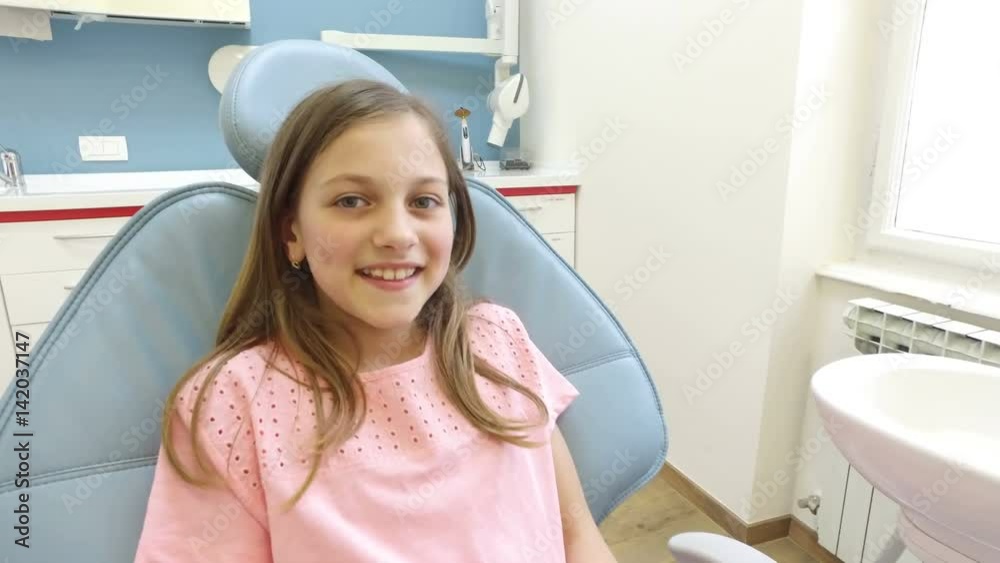 Close up of young handsome man holding smartphone with photo of dental X-ray at dentist, cute little girl standing next to him Close up of young handsome man holding smartphone with photo of dental X-ray at dentist, cute little girl standing next to him