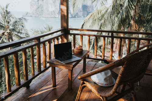 The photo was made in the hotel on Krabi province in Thailand. On the veranda opens an amazing view of Railay peninsula. The photo shows a tourist thing of the 21st century - a computer.