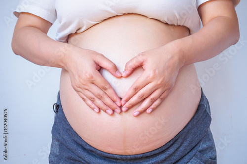 Wallpaper Mural pregnant woman hands forming heart on her belly Torontodigital.ca