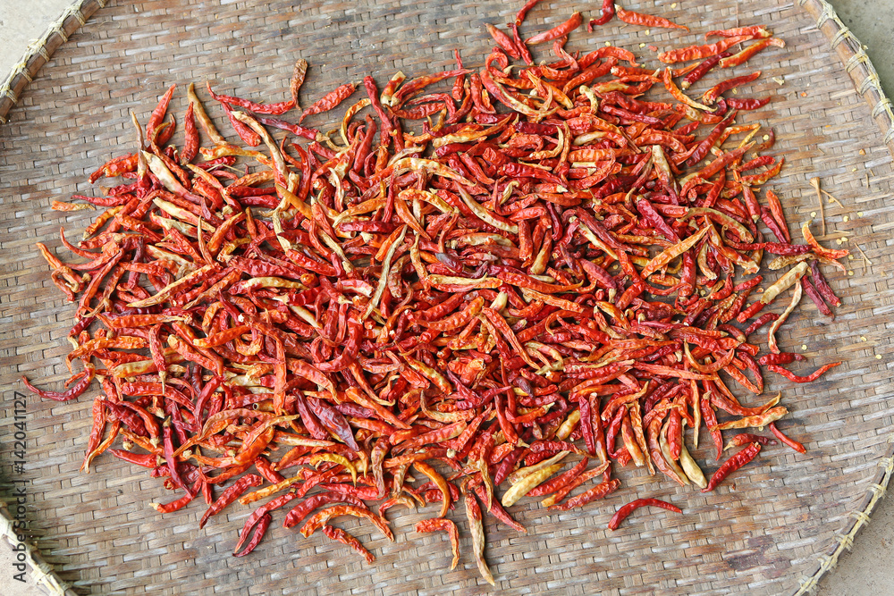 Fototapeta premium Dried red hot chilli peppers on bamboo weave basket