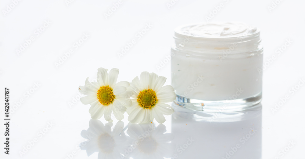 Moisturizing cream and chamomile on white background Moisturizing cream and chamomile on white background