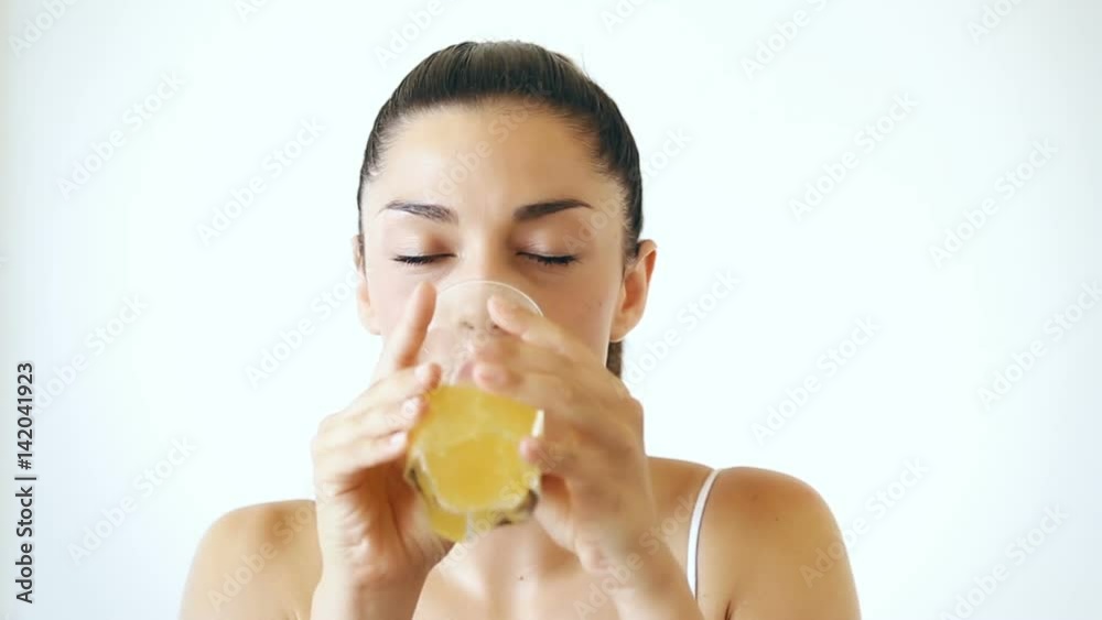 Close up portrait of attractive woman drinking juice on isolated white background Close up portrait of attractive woman drinking juice on isolated white background