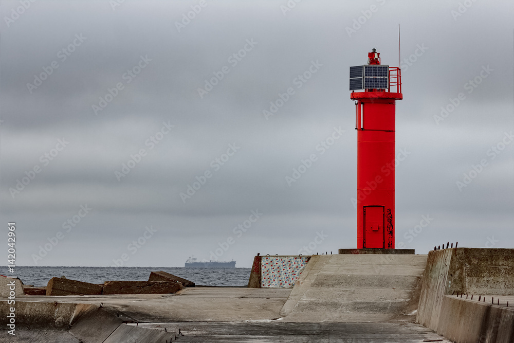Breakwater dam with red lighthouse in Riga, Europe