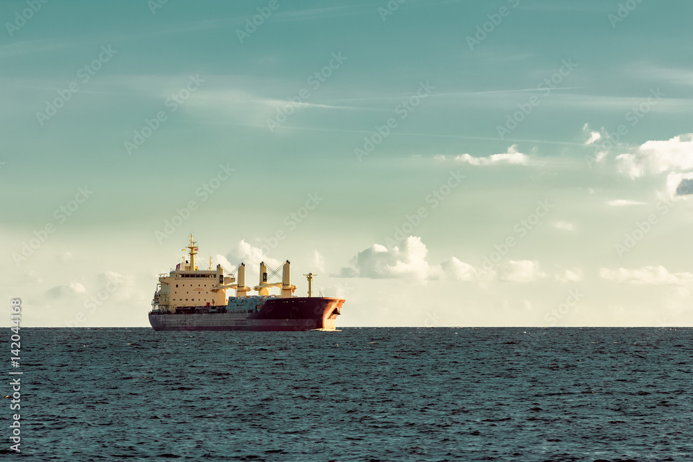 Red cargo ship (bulk carrier) sailing in open sea