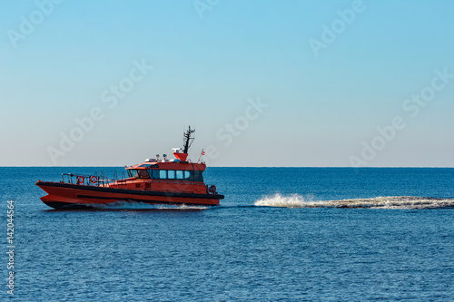 Orange pilot ship moving fast from Baltic sea