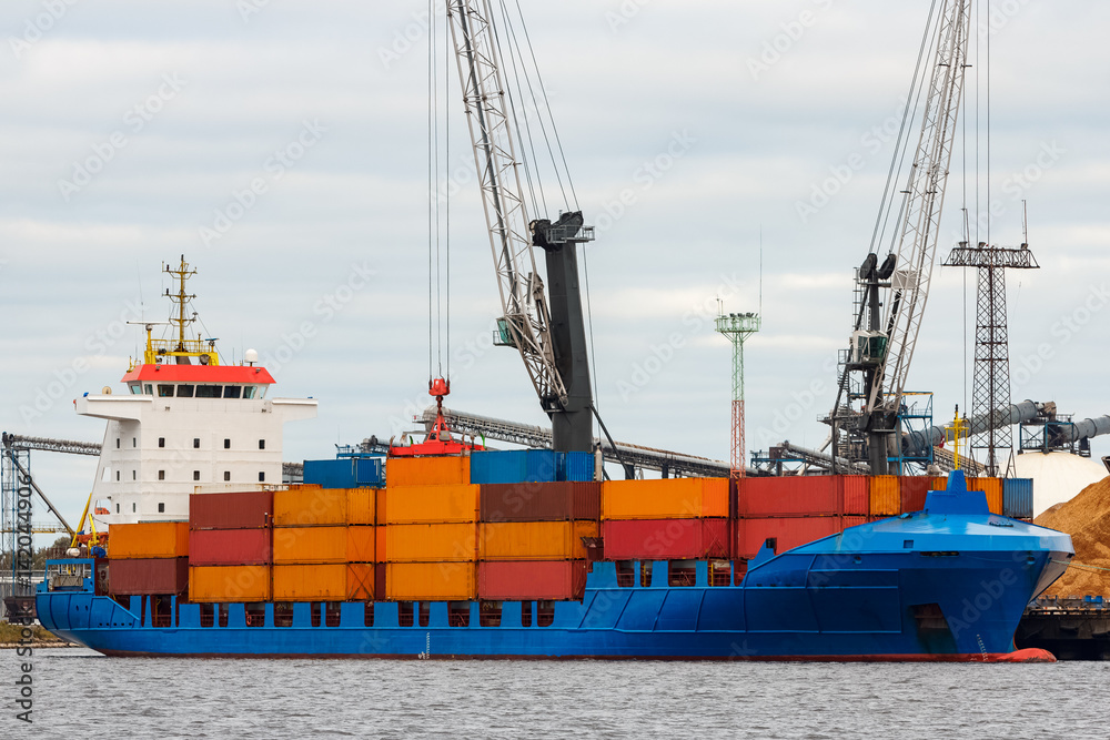 Blue container ship loading in cargo port of Europe