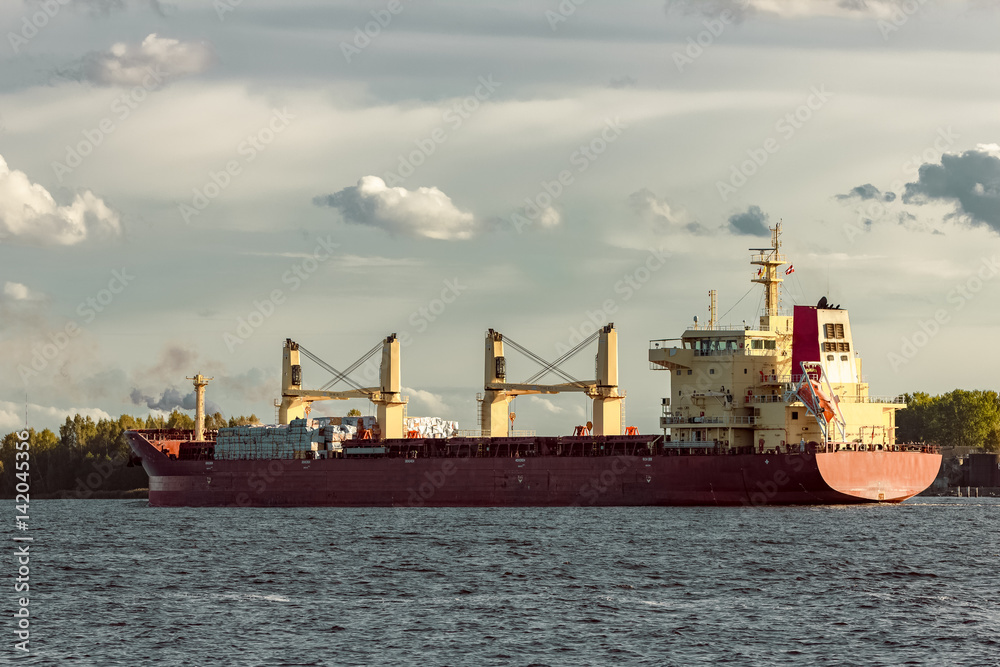 Red cargo ship sailing to the port of Riga Red cargo ship sailing to the port of Riga