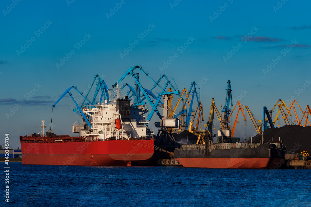 Red cargo ship loading in the port of Riga, Europe