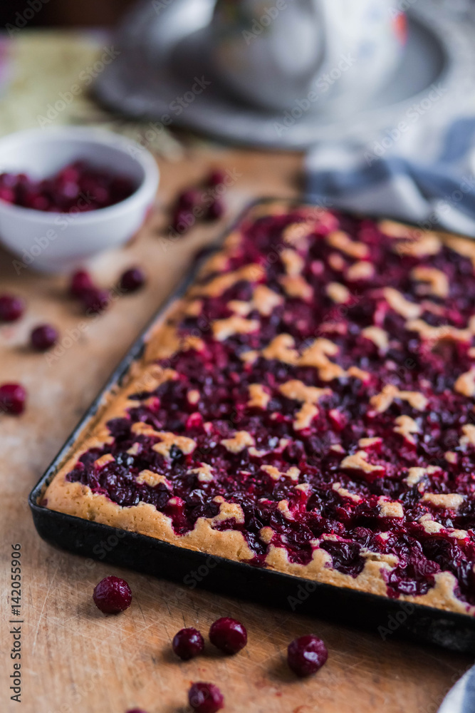 cherry fruit pie on a black baking tray on wooden Board with white blue kitchen towels close-up cherry fruit pie on a black baking tray on wooden Board with white blue kitchen towels close-up