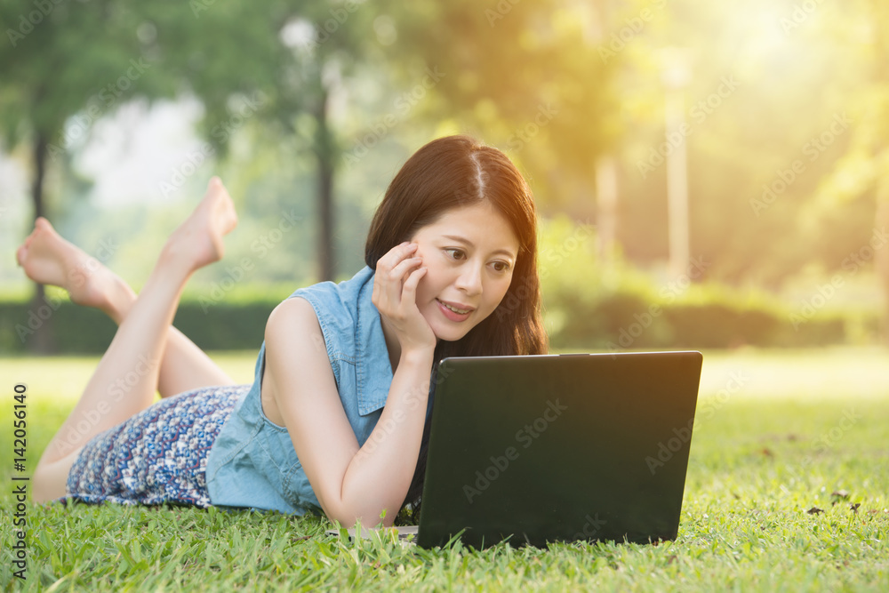 beautiful asian woman using computer on grass beautiful asian woman using computer on grass