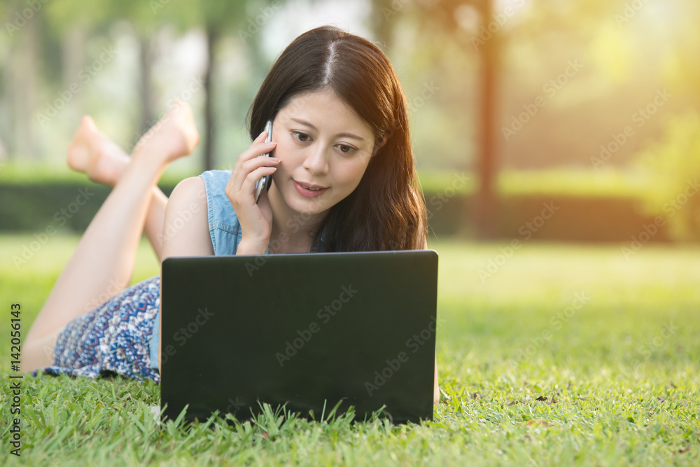 beautiful asian woman using computer smartphone on grass beautiful asian woman using computer smartphone on grass