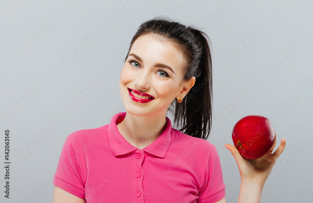 Young beautiful sexy girl with dark hair, holding big red apple to enjoy the taste and are dieting, healthy eating and organic foods, feeling temptation, smile, teeth. Young beautiful sexy girl with dark hair, holding big red apple to enjoy the taste and are dieting, healthy eating and organic foods, feeling temptation, smile, teeth.