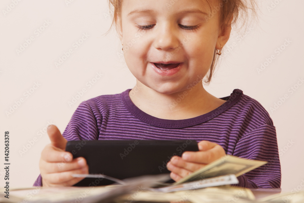 Very happy business baby girl with smart phone and dollar banknotes celebrating good news. (Humorous picture) Very happy business baby girl with smart phone and dollar banknotes celebrating good news. (Humorous picture)