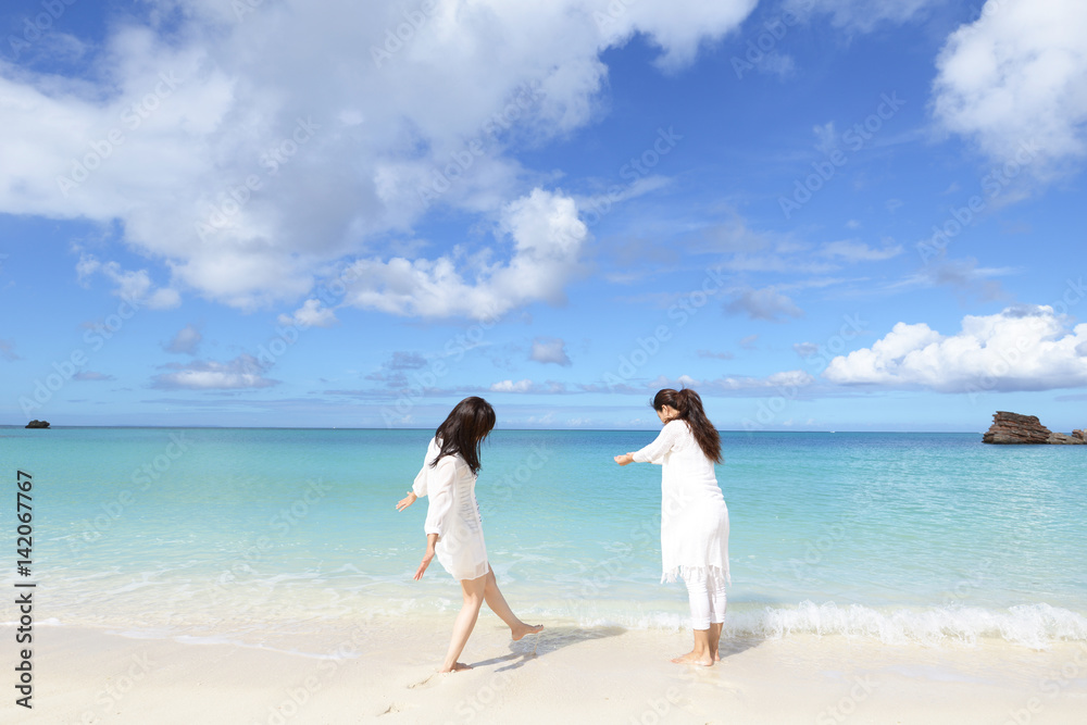 海辺で遊ぶ二人の女性