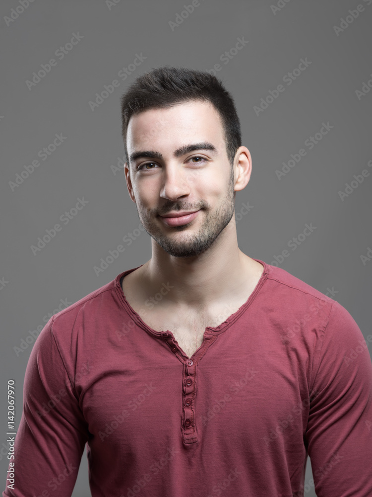 Obraz premium Happy young stylish stubble man smiling at camera over gray background