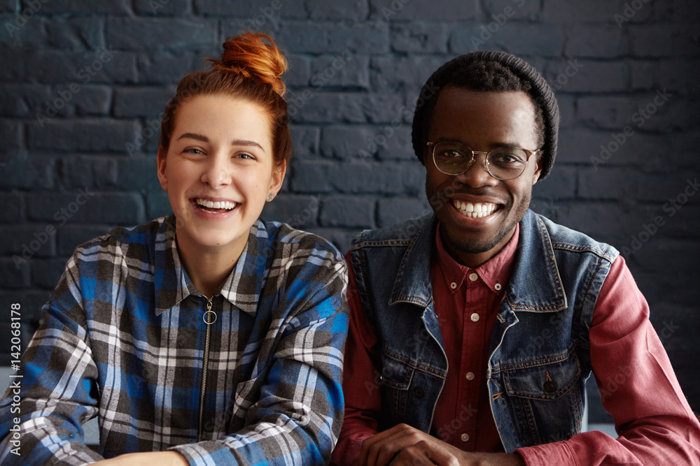Indoor shot of happy interracial couple having good time together ...