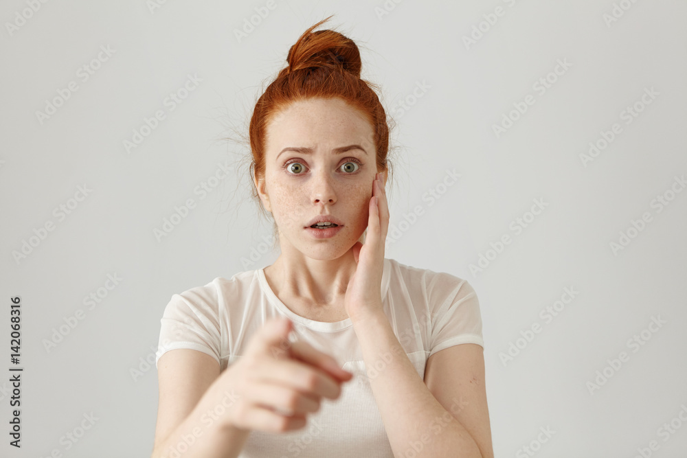Portrait of scared bug-eyed young redhead female having fearful terrified  expression, frightened with something while pointing her index finger at  camera. Danger, risk, accusation or recognition Stock Photo | Adobe Stock