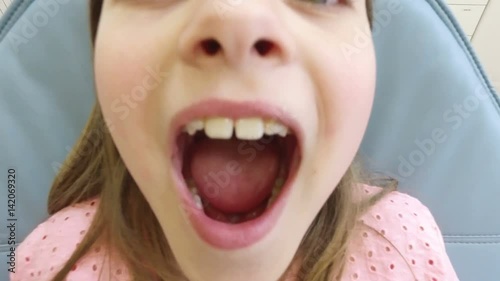 Close up of cute little girl at dentist, looking at camera and smiling