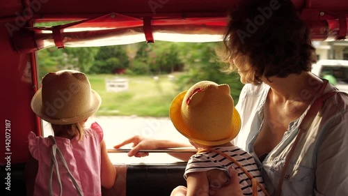 Young mother with two small daughters riding in a taxi tuk-tuk and look around