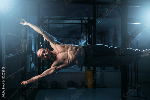 Fotografie Athlete with muscular body training on bar