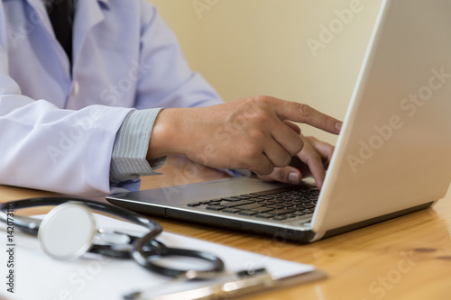 Doctor showing medical records on his computer  he is pointing at the screen in clinic