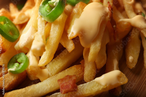 Delicious cheese fries with sliced pepper as background